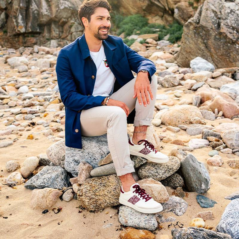 Modèle portant une paire de baskets en cuir avec des motifs ethniques artisanaux, lookbook. Saigon Classique burgundy.