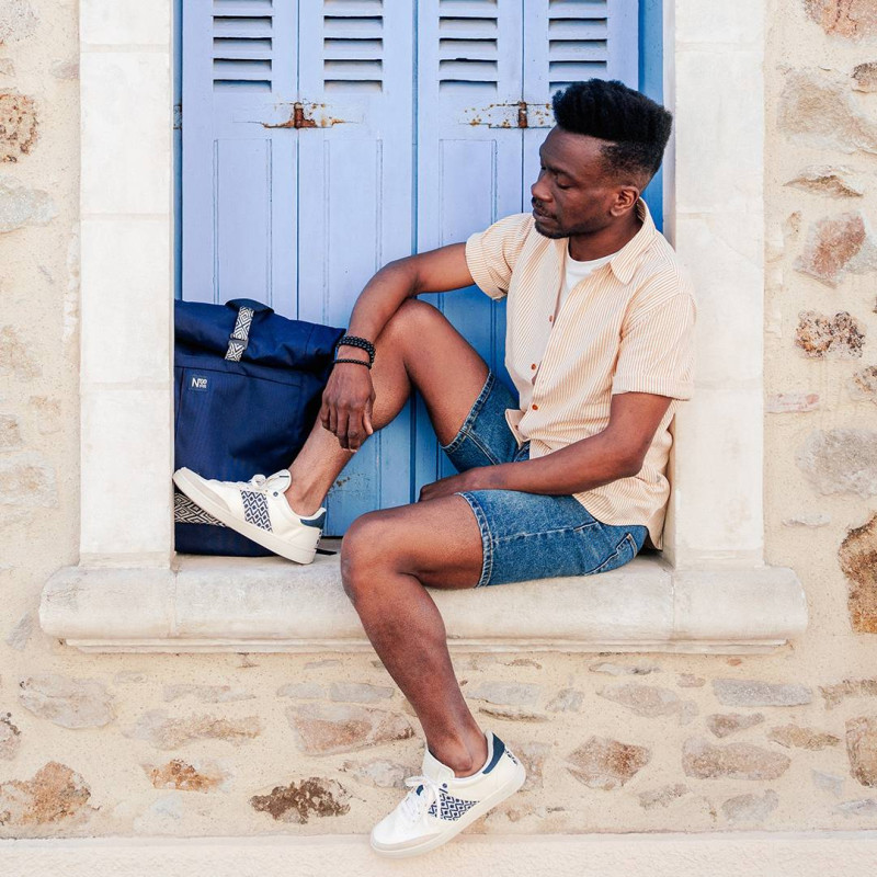 Modèle portant une paire de baskets en cuir avec des motifs ethniques artisanaux, lookbook. Saigon Classique Dark grey.