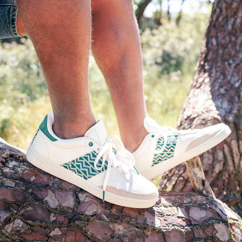 Modèle portant une paire de baskets en cuir avec des motifs ethniques artisanaux, lookbook. Saigon Classique Green.