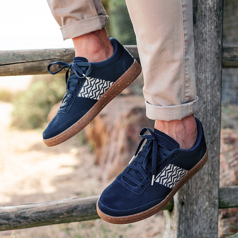 Modèle portant une paire de baskets en daim avec des motifs ethniques artisanaux, lookbook. Saigon Suede Navy.