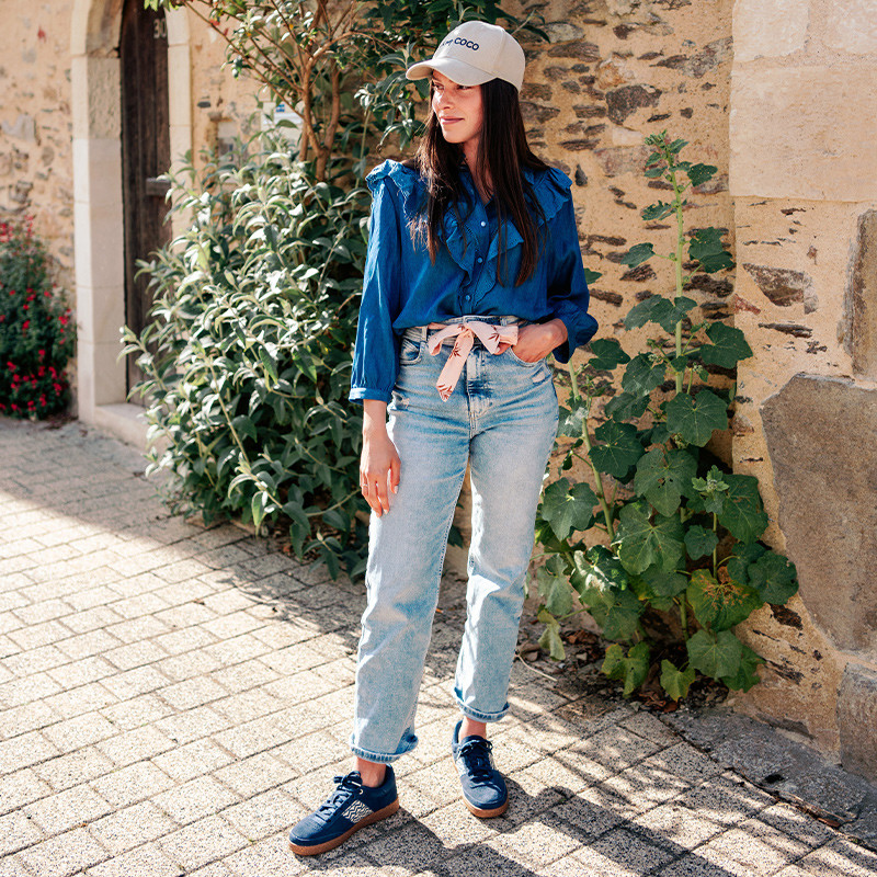 Modèle portant une paire de baskets en daim avec des motifs ethniques artisanaux, lookbook. Saigon Suede Navy.