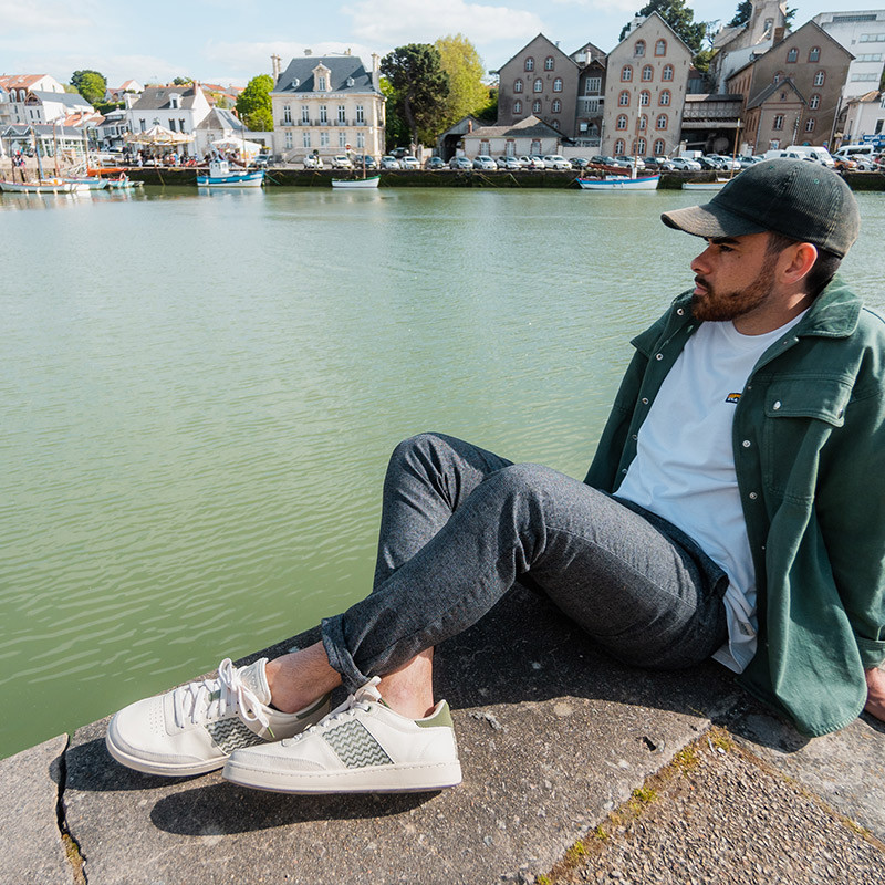 Modèle portant une paire de baskets en cuir avec des motifs ethniques artisanaux, lookbook. Saigon Classique Olive.