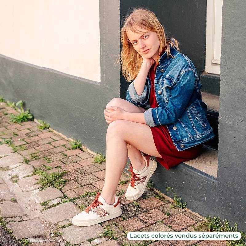 Femme portant une paire de baskets en cuir avec des motifs ethniques artisanaux, lookbook. Saigon Classique Terracotta.